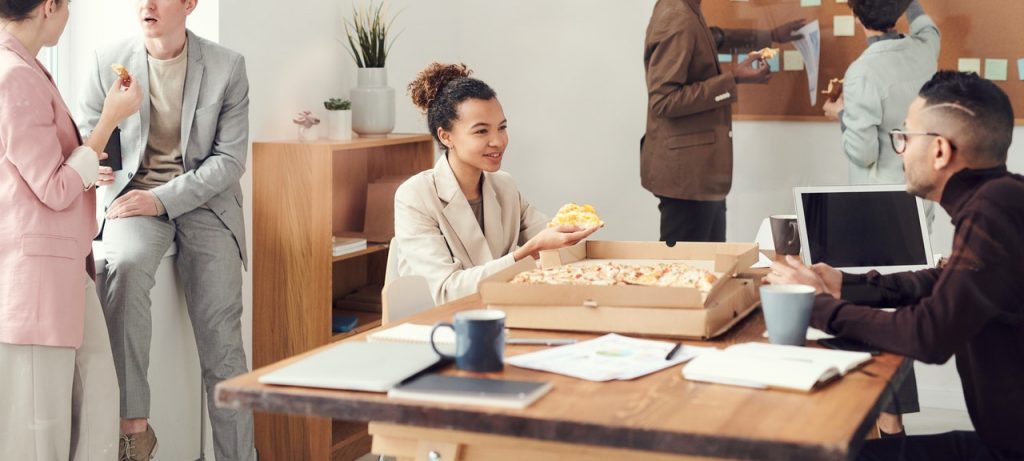 image of people eating pizza at work for blog by Metis HR on working time regulations 