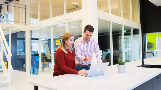 Image of a man and a woman at a laptop for a blog by Metis HR on should you use an HR consultant