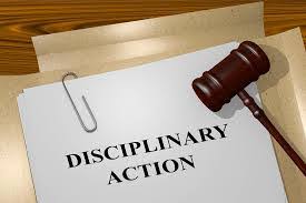 a picture of papers labelled disciplinary action to depict what is a disciplinary hearing