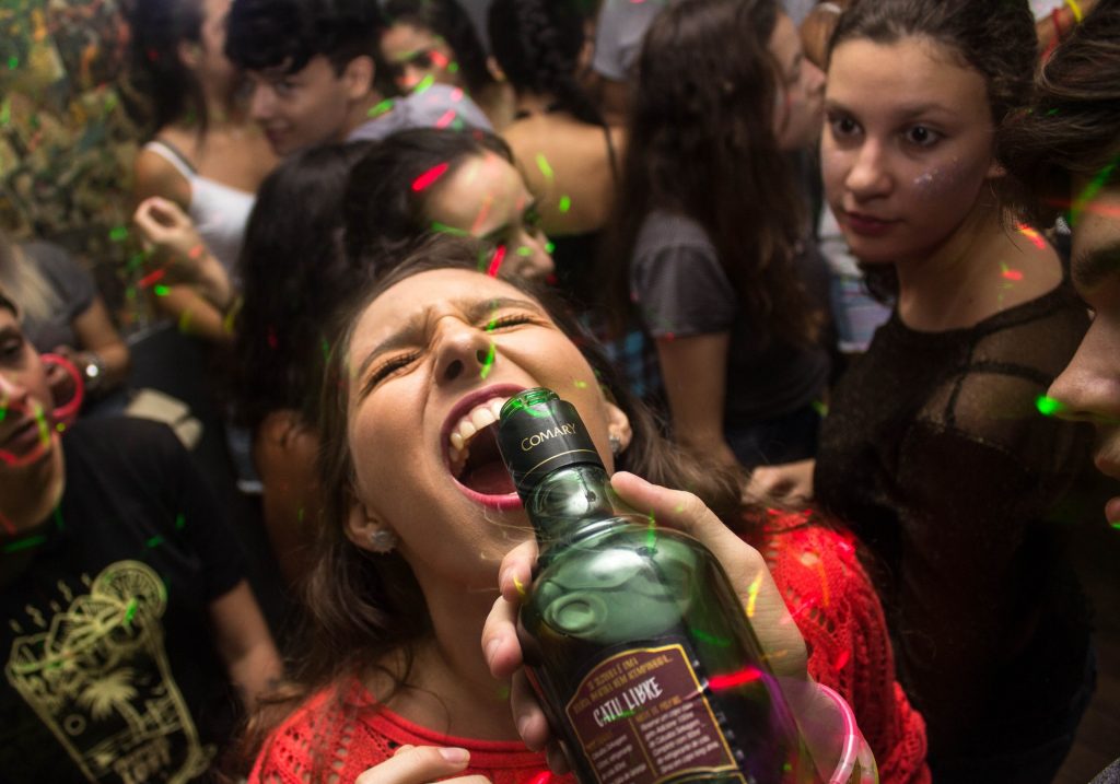 iamge of woman having alcohol poured in mouth at office christmas party 