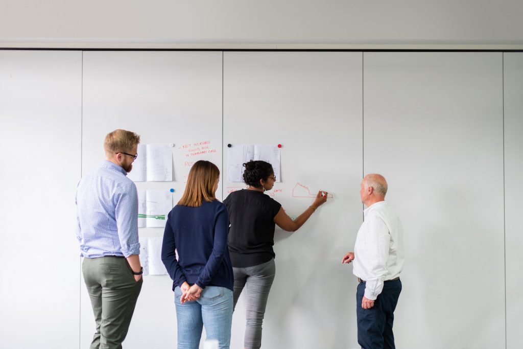 image of people working on a white board for blog by Metis HR on getting the most out of an HR Advisor